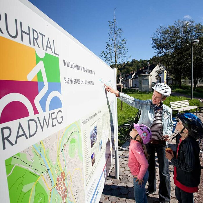 Cycling people in front of a map